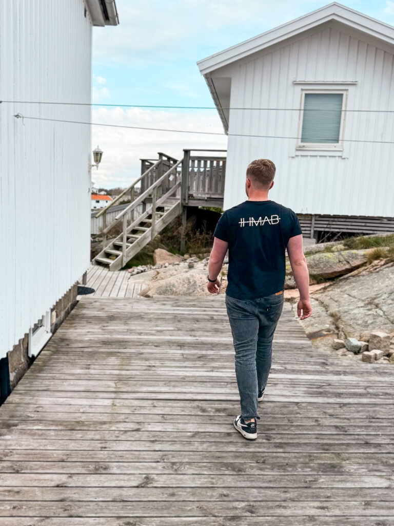 Vaktmästare på IHMAB sköter om en fastighet i Väjern. Iklädd i IHMAB kläder tittar han till huset.